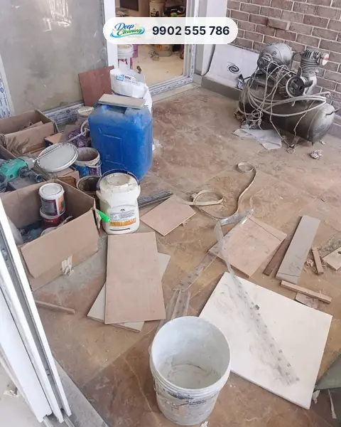 Balcony floor covered in paint tins, plywood offcuts and dust