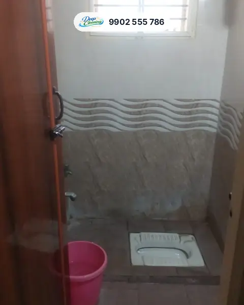 Bathroom with Indian-style toilet and stained lower wall tiles
