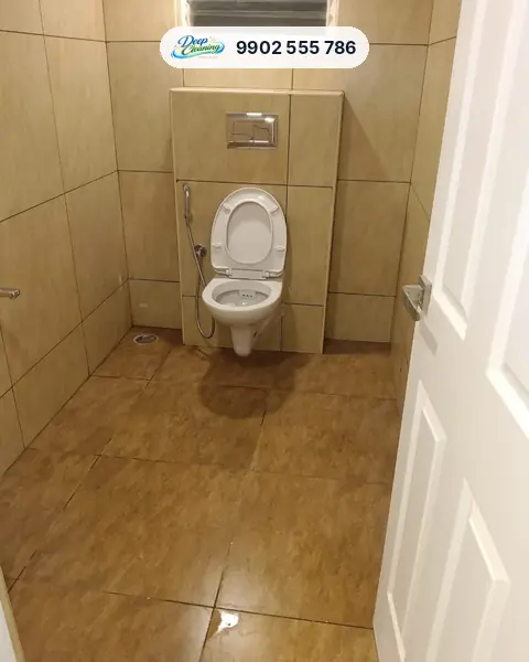 Bathroom with wall-hung commode and a freshly washed, wet tiled floor