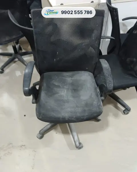 Black mesh office chair with dust and white marks on the seat