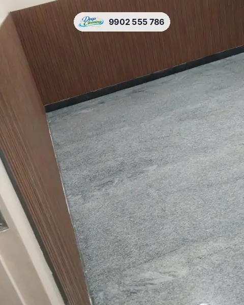Clean granite floor meeting wooden wall panelling in a corner