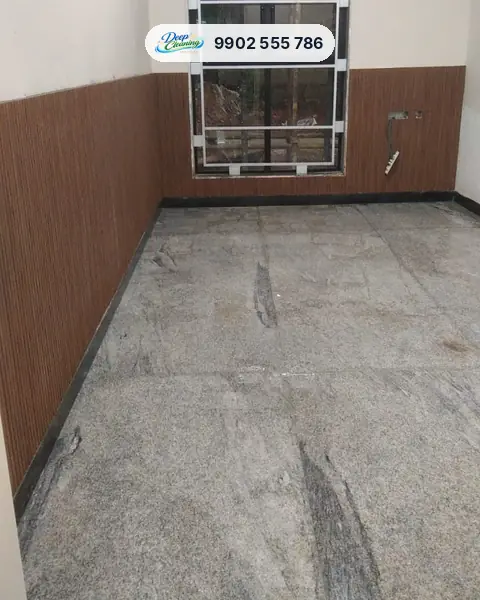 Room with wood-panelled walls and a granite floor streaked with cement