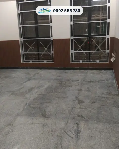 Room with two large windows and a dusty, streaked granite floor
