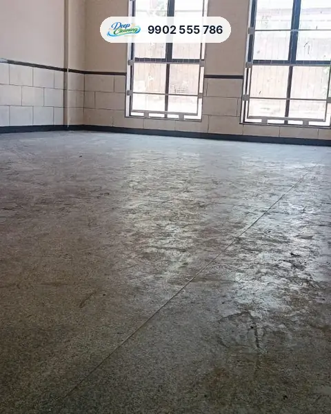 Wide view of a dusty granite hall floor below two windows