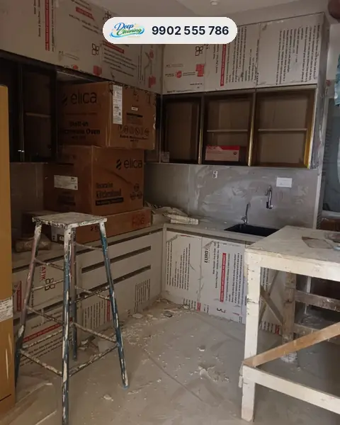 Unfinished modular kitchen with appliance boxes, film-covered shutters and debris
