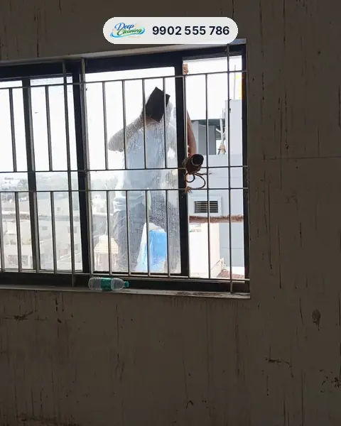 Cleaner washing window glass from outside in a newly built flat
